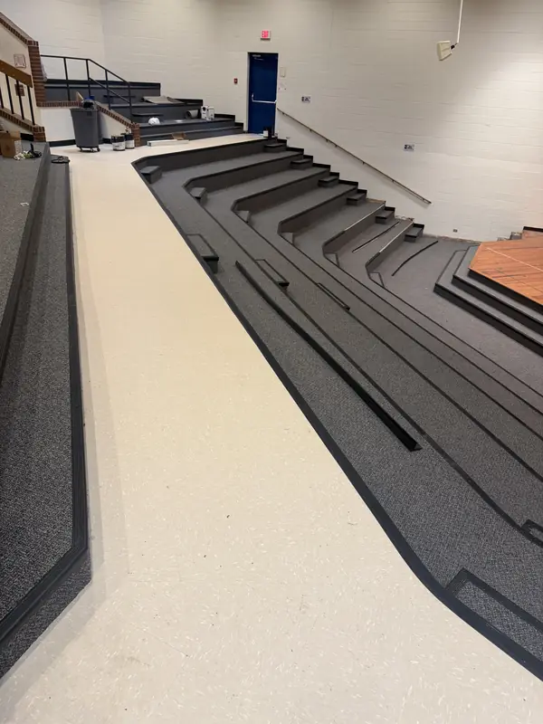 Auditorium flooring with carpeted tiers and a vinyl aisle