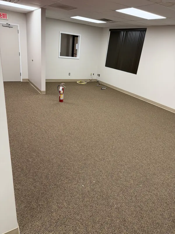 New commercial carpet installed in an open office space with drop ceiling