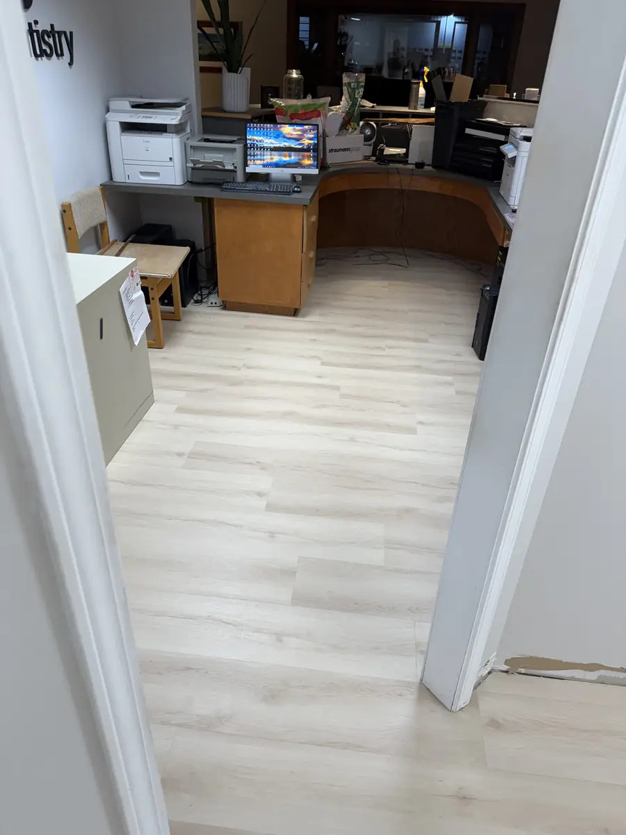 Light oak commercial LVP flooring installed in a dental office reception area