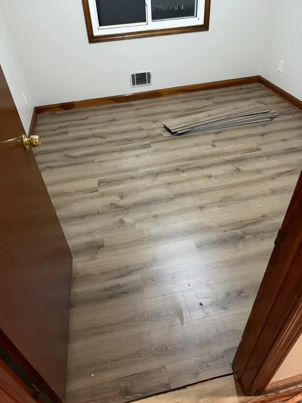 Gray luxury vinyl plank flooring installed in a bedroom